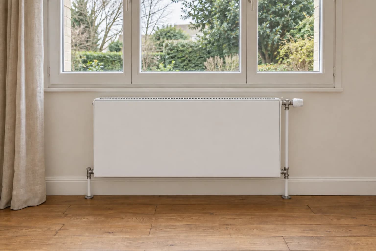 Même pièce avec radiateur blanc à façade lisse, raccordements soignés et mur remis en état.